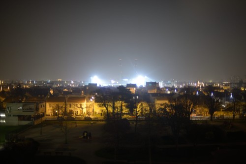 En augmentant la vitesse d'obturation, on arrive à distinguer les cheminées à environ 2 km derrière les lumières du stade qui sont à moins d'1 km...